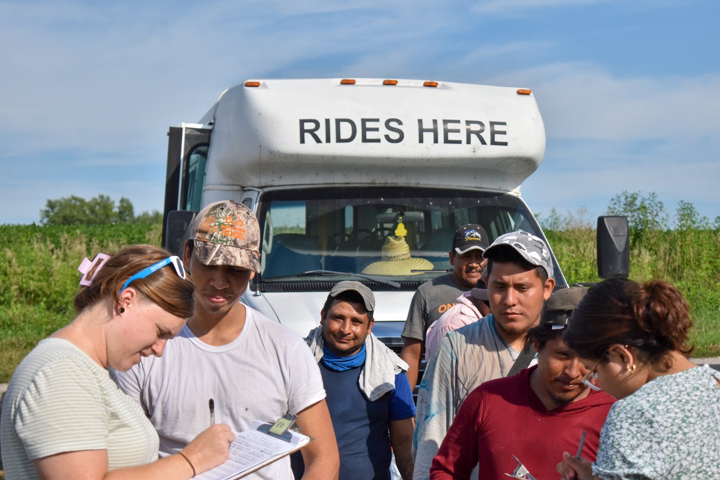 Workers sign up to get help setting up healthcare appointments from the Migrant Farmworkers Assistance Fund at an apple orchard just outside of Waverly, Missouri. Credit: Zach Perez, KCUR 89.3