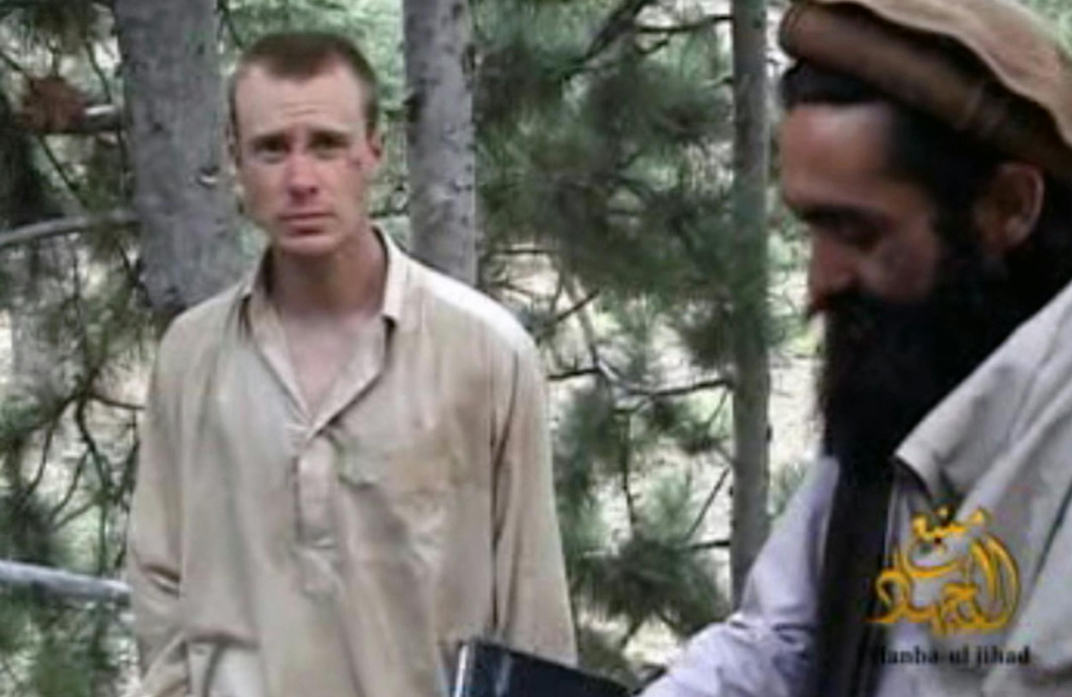 FILE - This file image provided by IntelCenter on Wednesday Dec. 8, 2010 shows a frame grab from a video released by the Taliban containing footage of a man believed to be Bowe Bergdahl, left.