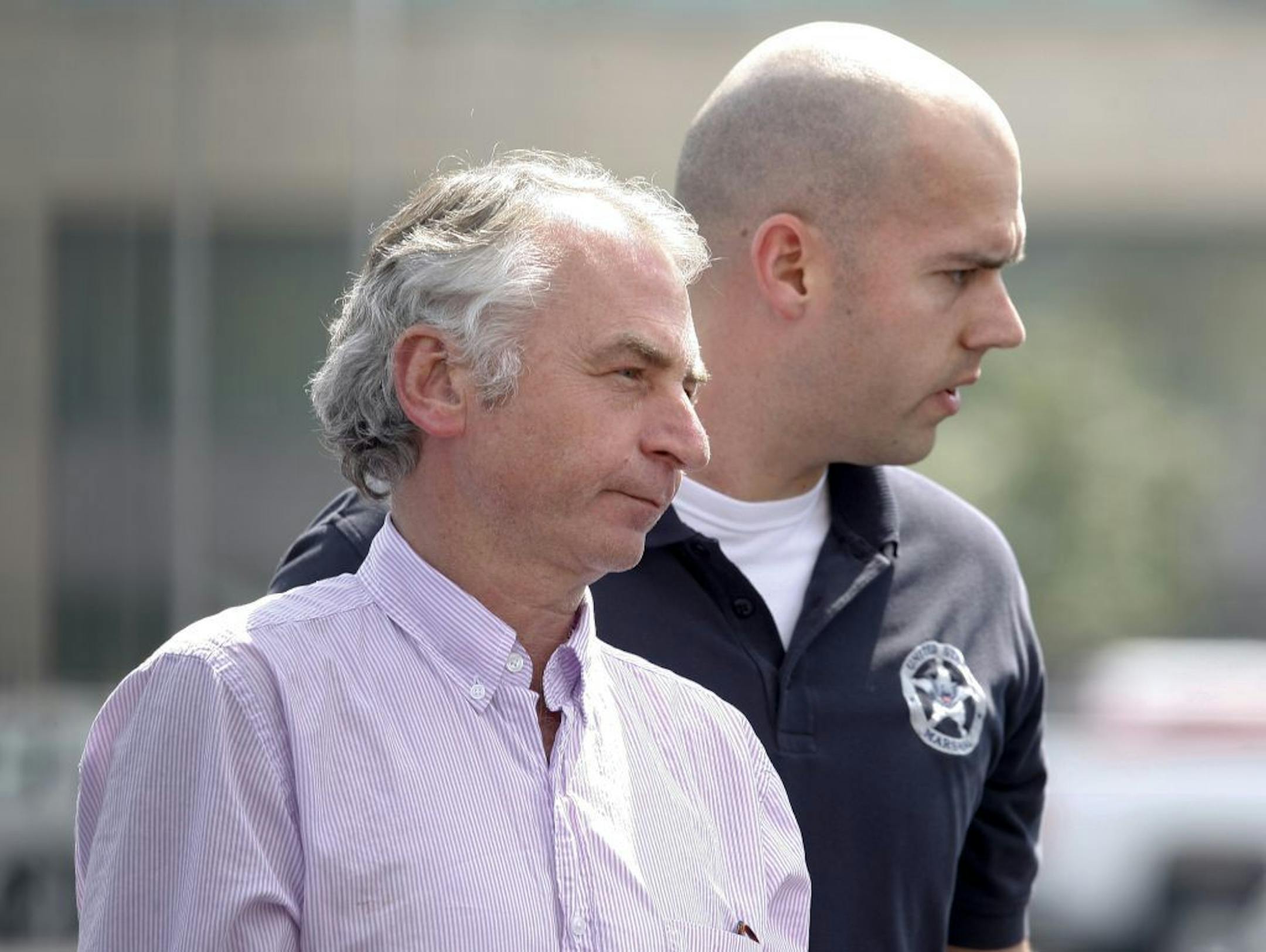 Paul Douglas Peters, left, of Sydney, Australia, is escorted from the Federal Courthouse in Louisville, Ky., after he was arraigned in connection with a bomb hoax in Australia, Tuesday, Aug. 16, 2011.