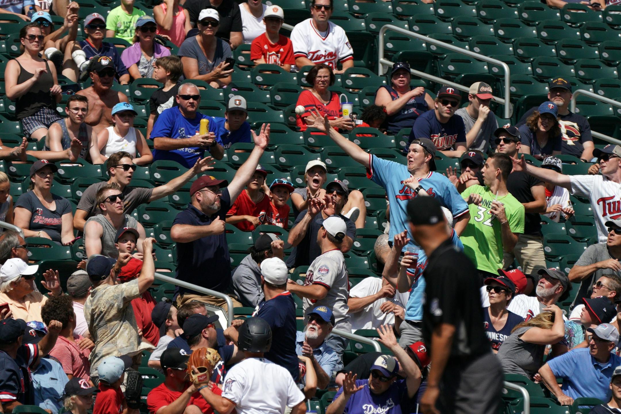 A group of fans tried to catch foul ball hit by Atlanta Braves left fielder Adam Duvall (23) in the seventh inning.