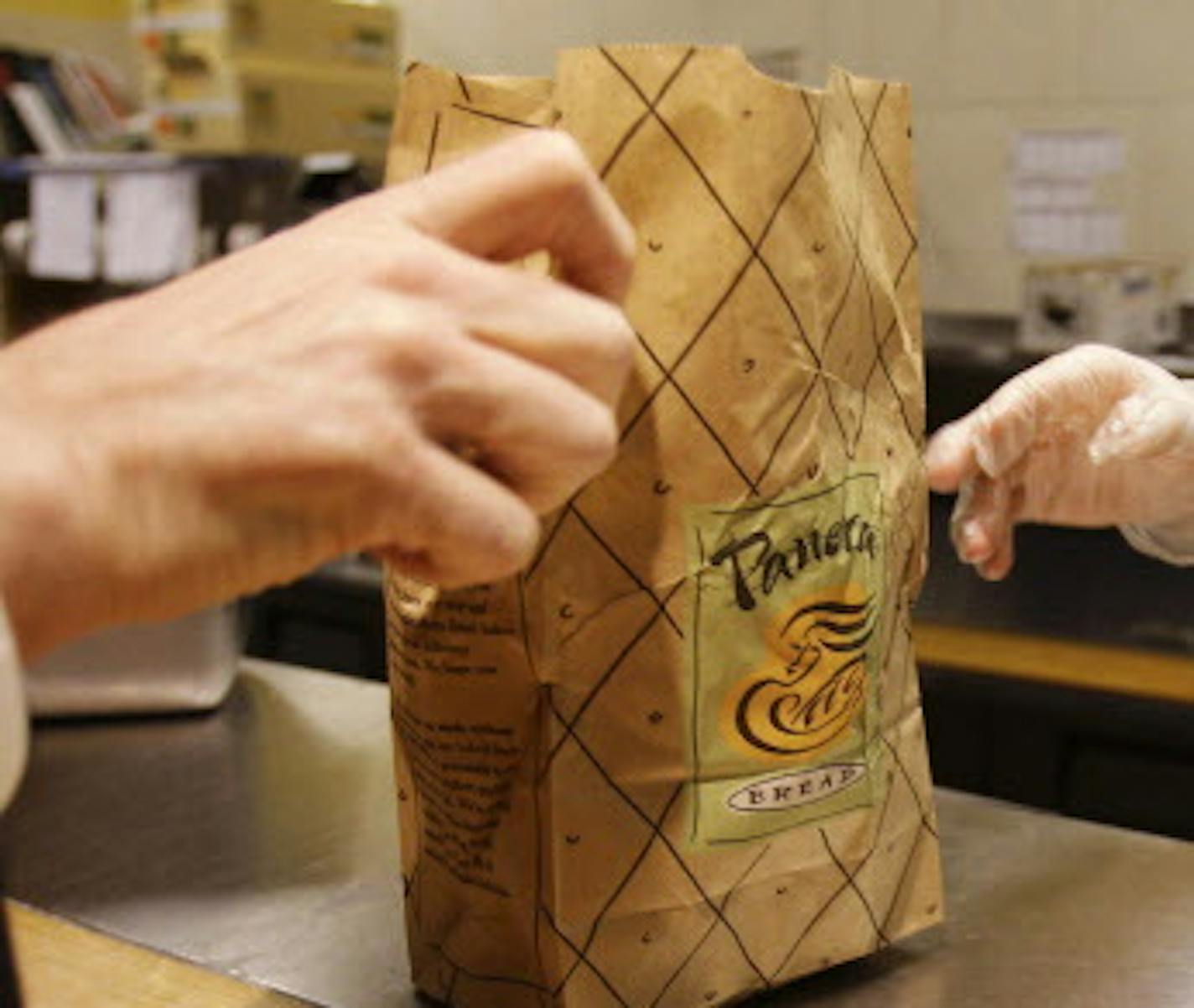 In this March 8, 2010, file photo, an employee passes an order to a customer at a Panera Bread store in Brookline, Mass.