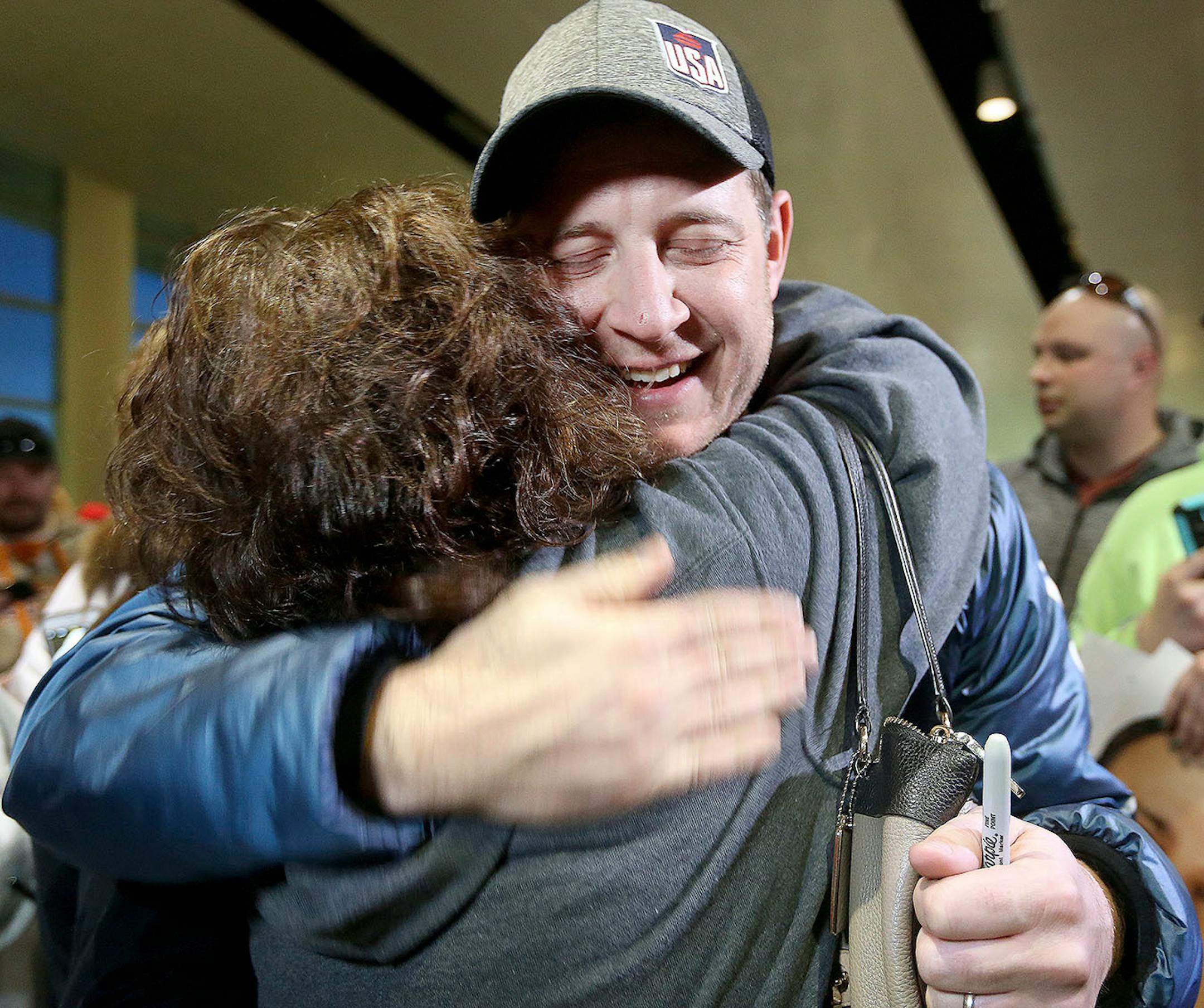 John Shuster of the Duluth curling team gets a big hug from follower Kim Hinz of Duluth during the Duluth curling team's homecoming at the Duluth International Airport Monday evening. Bob King / rking@duluthnews.com