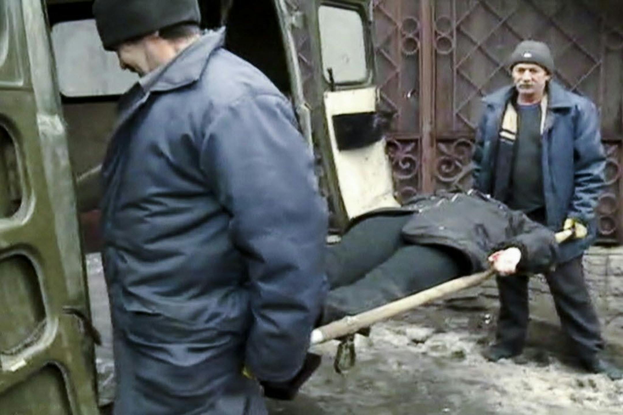 In this image made from the Russian RU-RTR television channel, a victim of a mortal shell which destroyed a trolley bus is carried away in Donetsk, eastern Ukraine, Thursday, Jan. 22, 2015.