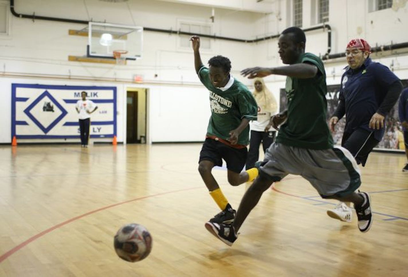 Street soccer players Hector Johnson, foreground, and Hanad Abdi pursue a loose ball with head coach Jose Acuna close behind during a night scrimmage at the Gethsemane Episcopal Church gym in downtown Minneapolis. The Up Top team is one of 23 teams of homeless youths and young adults from across the country competing in the Street Soccer USA Cup in Washington, D.C., on July 30.