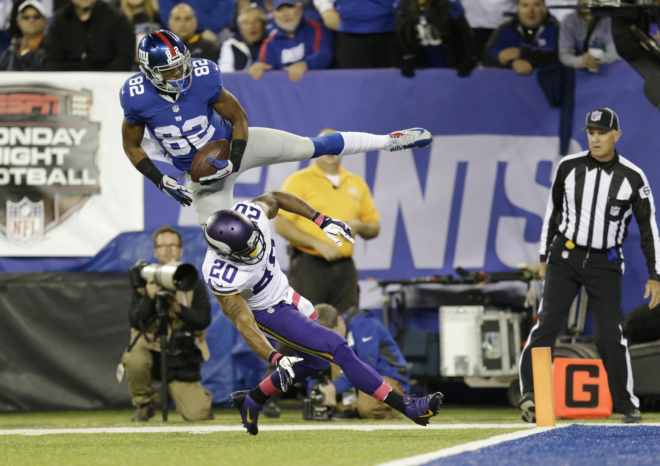 New York Giants wide receiver Rueben Randle (82) catches a pass for a touchdown in front of Minnesota Vikings' Chris Cook (20) during the first half of an NFL football game Monday, Oct. 21, 2013 in East Rutherford, N.J. (AP Photo/Julio Cortez)