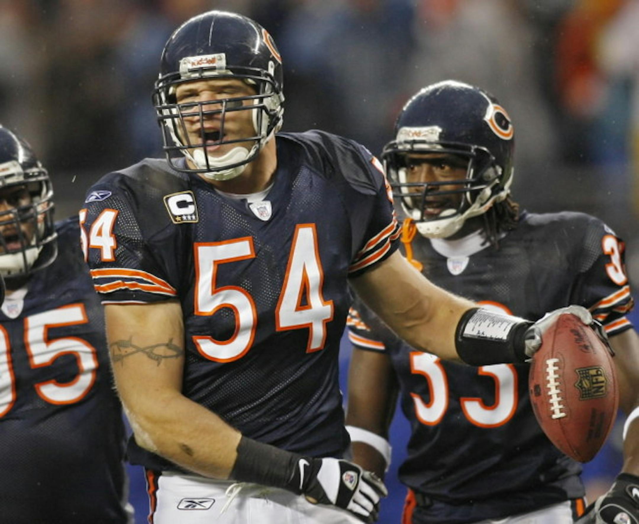 Chicago Bears' Brian Urlacher, center, celebrates, with teammates Anthony Adams, left, and Charles Tillman, right, after he intercepted a pass by New York Giants' Eli Manning on Dec. 2.