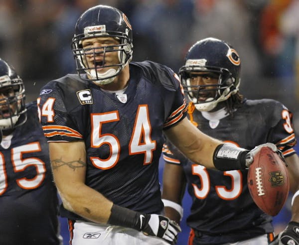 Chicago Bears' Brian Urlacher, center, celebrates, with teammates Anthony Adams, left, and Charles Tillman, right, after he intercepted a pass by New 