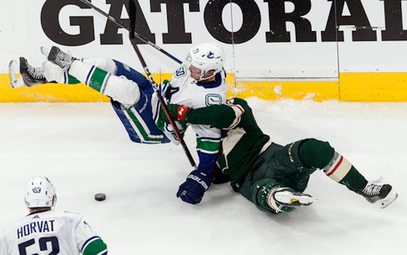 Minnesota Wild's Joel Eriksson Ek (14) and Vancouver Canucks' Loui Eriksson (21) collide during third-period NHL hockey game action in Edmonton, Alberta, Thursday, Aug. 6, 2020. (Jason Franson/The Canadian Press via AP)