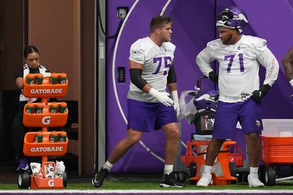 Vikings offensive tackle Brian O'Neill (75) talked with fellow offensive tackle Christian Darrisaw (71) during a practice earlier this year.