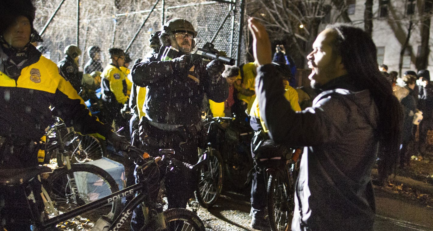 A Minneapolis police officer confronted protesters at the west entrance of the Fourth Precinct headquarters on Wednesday.