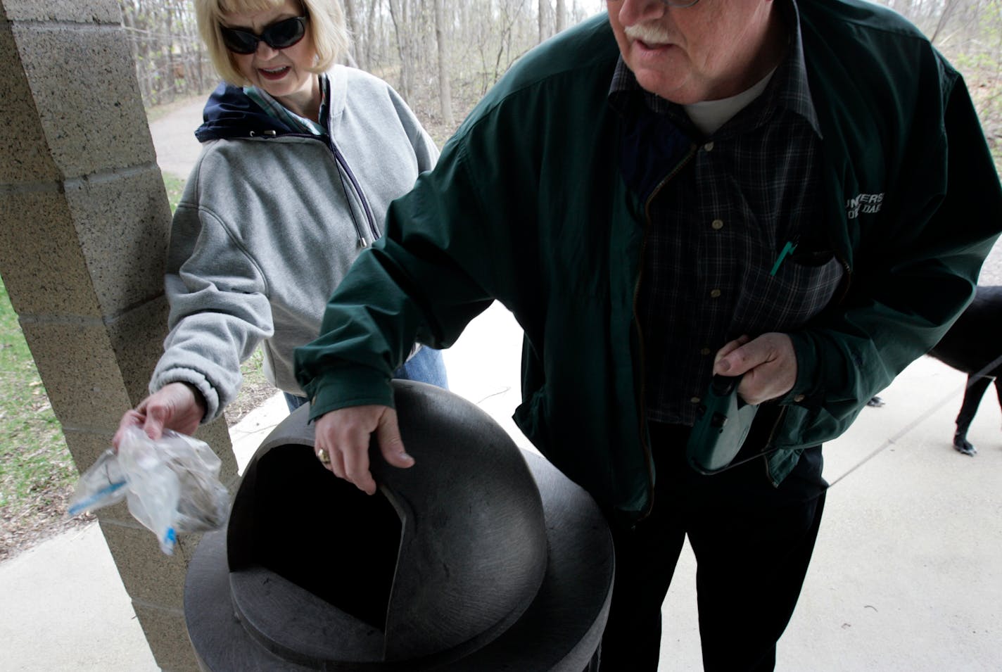 Lyleen and James Holmen of Minnetonka threw away bags of their dog's waste after a walk in Purgatory Park. The Holmens take their dog, Bella, a black lab, to Purgatory Park about six times a week.