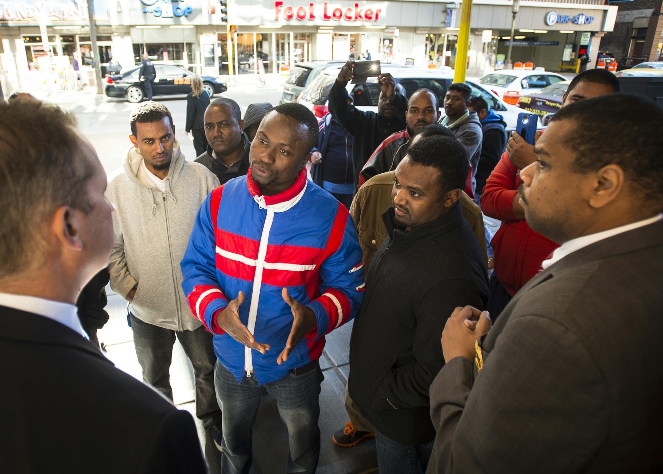 Cab Drivers Association spokesman Mohamed Dorley, center, expressed his group's grievances to Marriott General Manager Rick Bertram, left, on Tuesday afternoon. The cab drivers believe that hotel doormen are cutting deals with limo drivers for clients and are shutting out cab drivers in the process. ] Aaron Lavinsky • aaron.lavinsky@startribune.com Dozens of cabs clogged traffic along 7th street in downtown Minneapolis in what police are calling civil disobedience on Tuesday, Oct. 13, 201