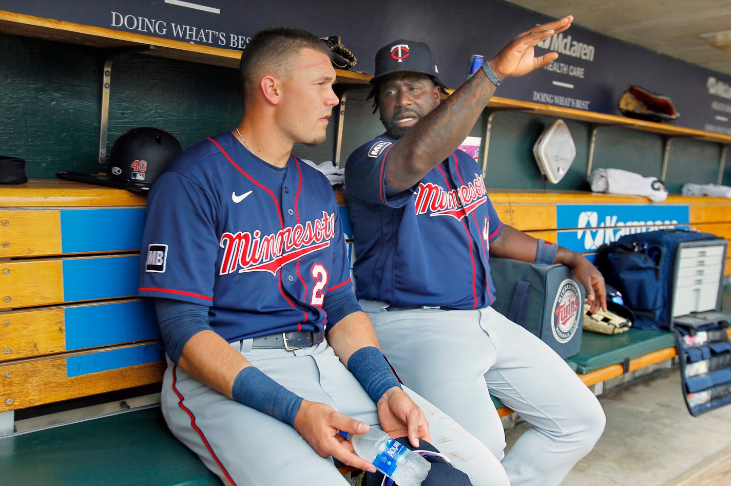 Minnesota Twins' Trevor Larnach, left, receives some instruction from first base coach Tommy Watkins during the second inning of a baseball game Sunday, July 18, 2021, in Detroit. (AP Photo/Duane Burleson)