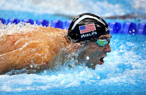 Michael Phelps swims in a three way tie for 2nd plae in the 100 butterfly.