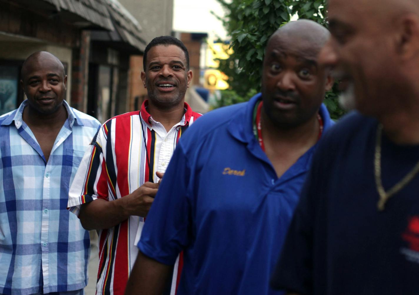 Marcel Thompson, Damon Drake, Derek Brown, and Steven Randall walk down Payne Ave. in St. Paul on Friday evening. ] Area youth workers patrol the streets of St. Paul to engage with youth. MONICA HERNDON monica.herndon@startribune.com St. Paul, MN 07/25/14