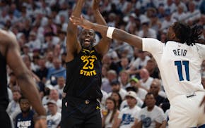 Warriors forward Draymond Green (23) shoots over the arm of Timberwolves center Naz Reid (11) in the second quarter in Game 1 of their Western Confere