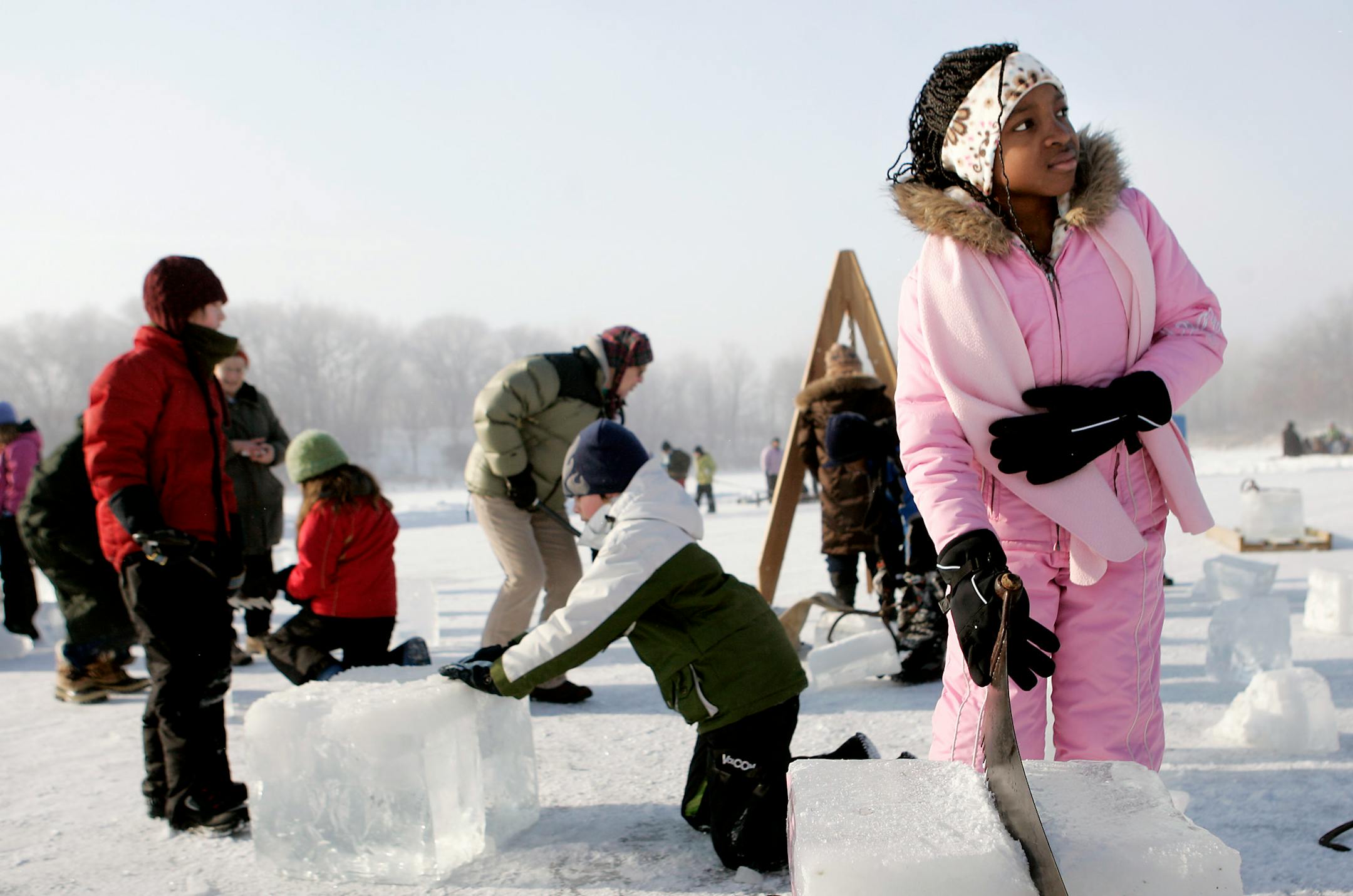 Jernise Agbenowossi, foreground, a fifth-grader from Kenwood Elementary School in Minneapolis, took a break from her sawing duties during an ice harvest history day at Hyland Park Reserve in Bloomington last week. The ice on the pond was about 15 inches thick.