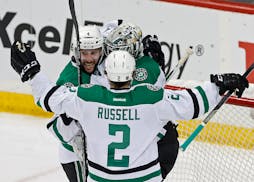 Dallas Stars' Jason Demers, left, and Kris Russell celebrate with goalie Antti Niemi, of Finland, after the Stars beat the Minnesota Wild 3-2 in Game 