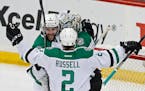 Dallas Stars' Jason Demers, left, and Kris Russell celebrate with goalie Antti Niemi, of Finland, after the Stars beat the Minnesota Wild 3-2 in Game 