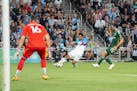Minnesota United defender D.J. Taylor (27) crosses the ball in front of Timbers defender Eric Miller (15) and goalkeeper Maxime Crépeau (16) during t