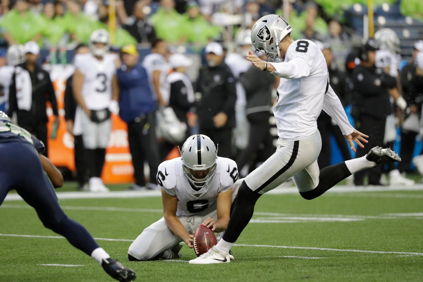 Oakland Raiders kicker Daniel Carlson (8) kicks a field goal as punter A.J. Cole holds during the first half of an NFL football preseason game against the Seattle Seahawks, Thursday, Aug. 29, 2019, in Seattle. (AP Photo/Elaine Thompson)