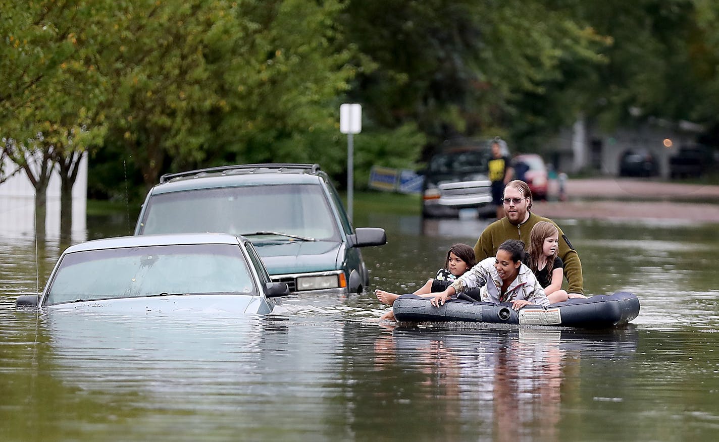 Ellery Forsythe pushed some kids on an air mattress to get a closer look at the submerged vehicles on a Waseca street, Thursday, September 22, 2016 in Waseca, MN.