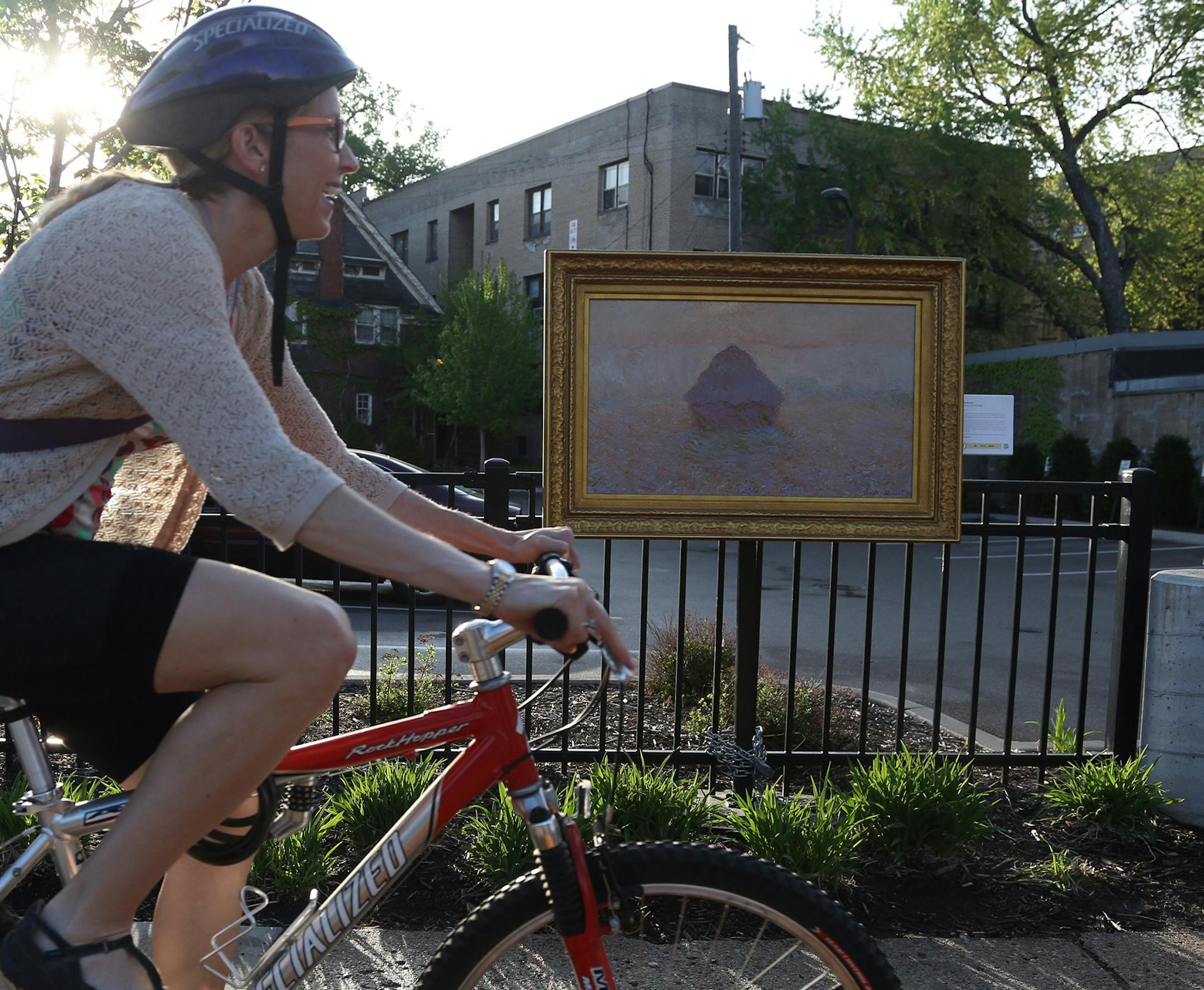 A copy of Claude Monet "Grainstack Sun in the Mist" hung on a fence as people go by in Uptown. ] (KYNDELL HARKNESS/STAR TRIBUNE) kyndell.harkness@startribune.com In celebration of its centennial the Mpls Institute of Arts has placed high-quality reproductions of three paintings from its collection at unexpected sites around Mpls in Minneapolis Min., Thursday, May 7, 2015.