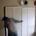Bridget Peake moves her closet door out of the way to access her clothes after it came the track in her apartment unit.