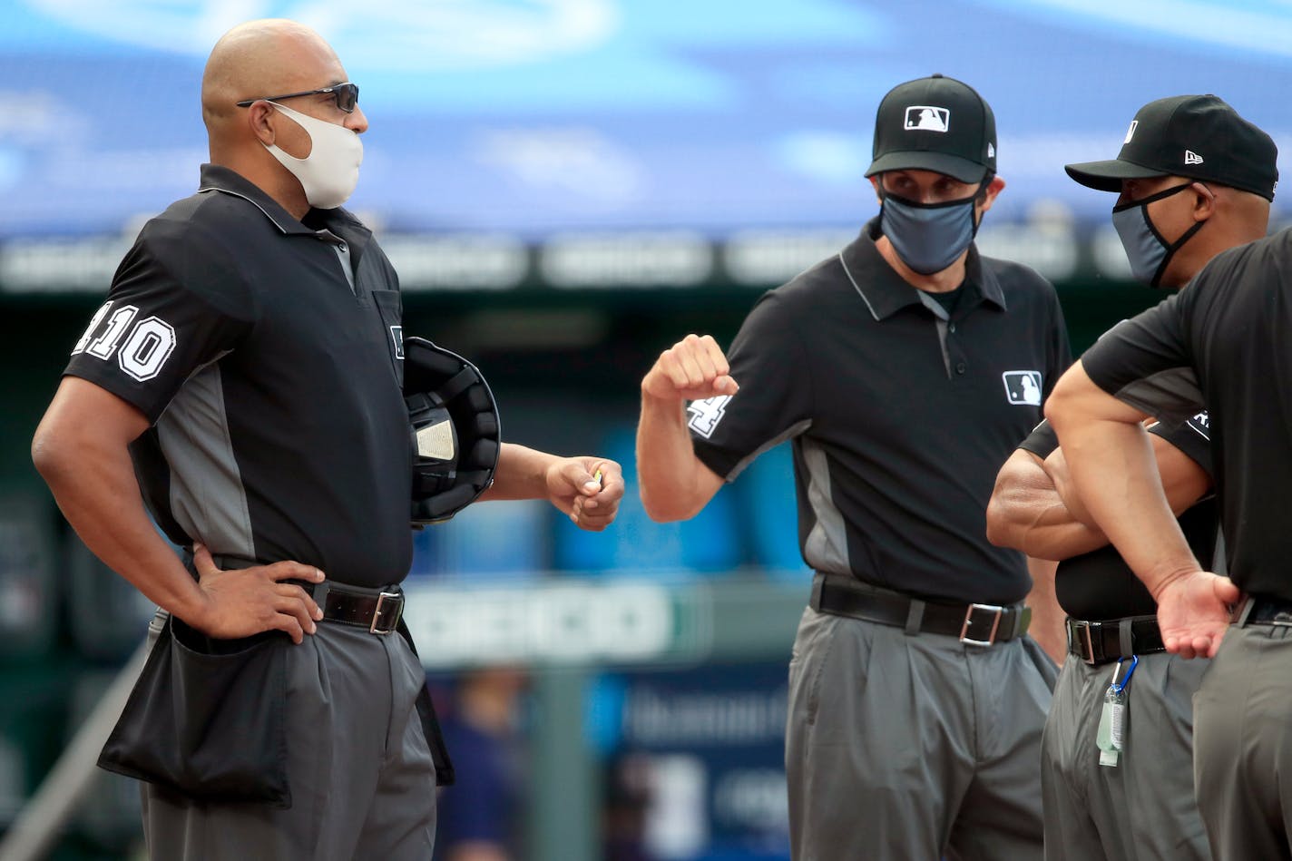 Home plate umpire Jose Navas fake fist-bumps with third base umpire John Tumpane before a baseball game between the Royals and the Twins at Kauffman Stadium