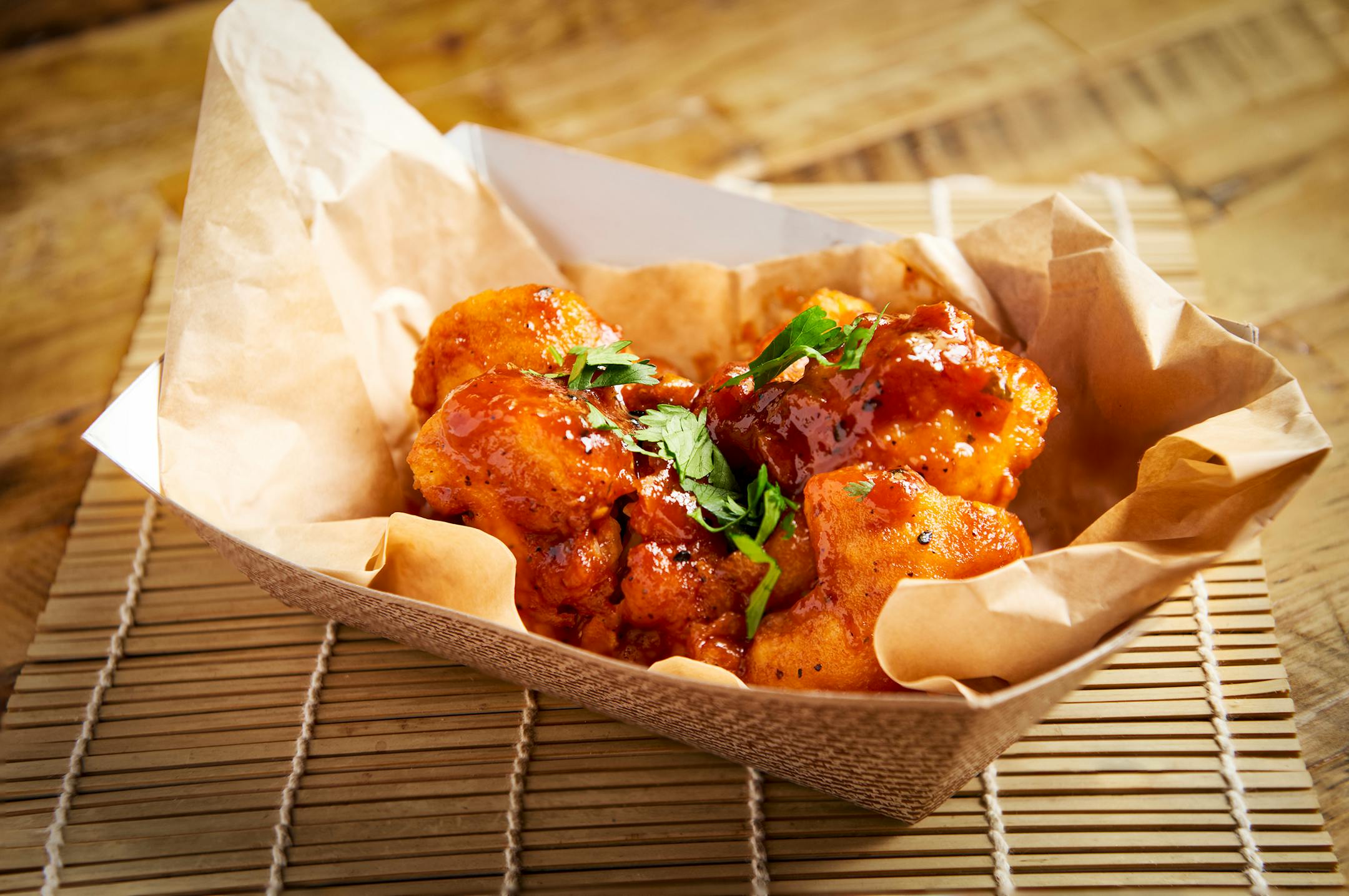 Earth Wings: Fresh cauliflower pieces dipped in a seasoned batter, deep-fried and smothered in organic sesame BBQ sauce. Vegan and gluten-free. At French Meadow Bakery & Cafe, located on the north side of Carnes Avenue between Nelson & Underwood streets.