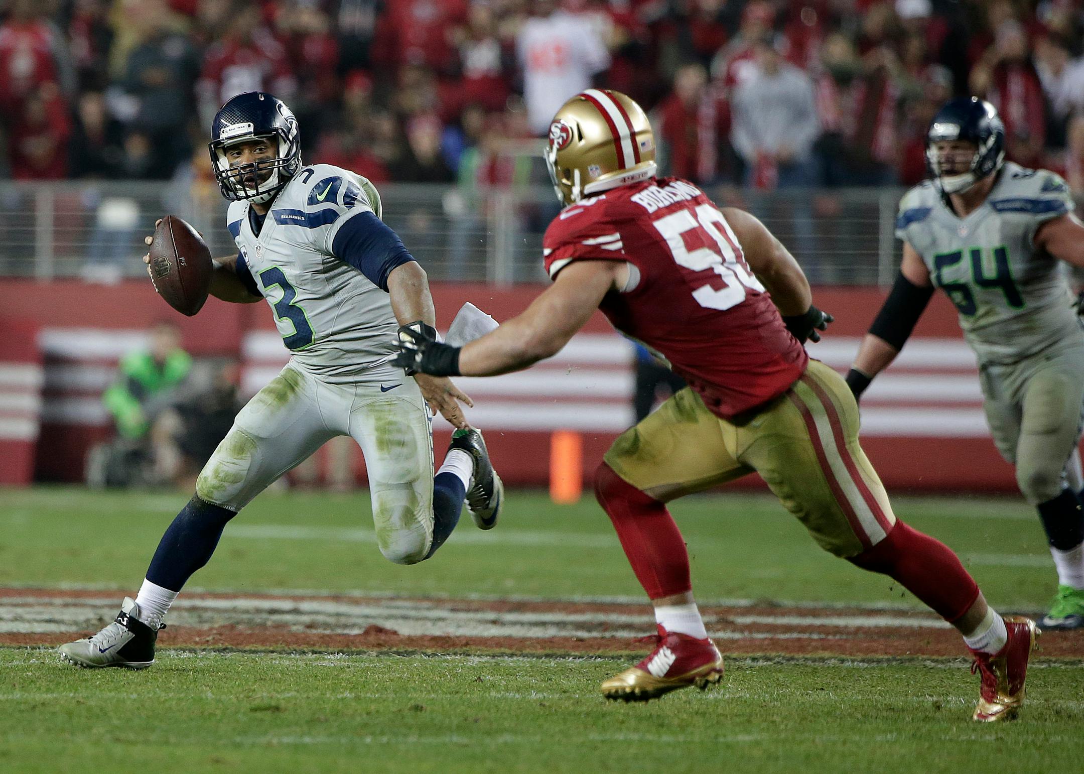 Seattle Seahawks quarterback Russell Wilson (3) runs against San Francisco 49ers inside linebacker Chris Borland (50) during the second half of an NFL football game in Santa Clara, Calif., Thursday, Nov. 27, 2014. (AP Photo/Marcio Jose Sanchez)