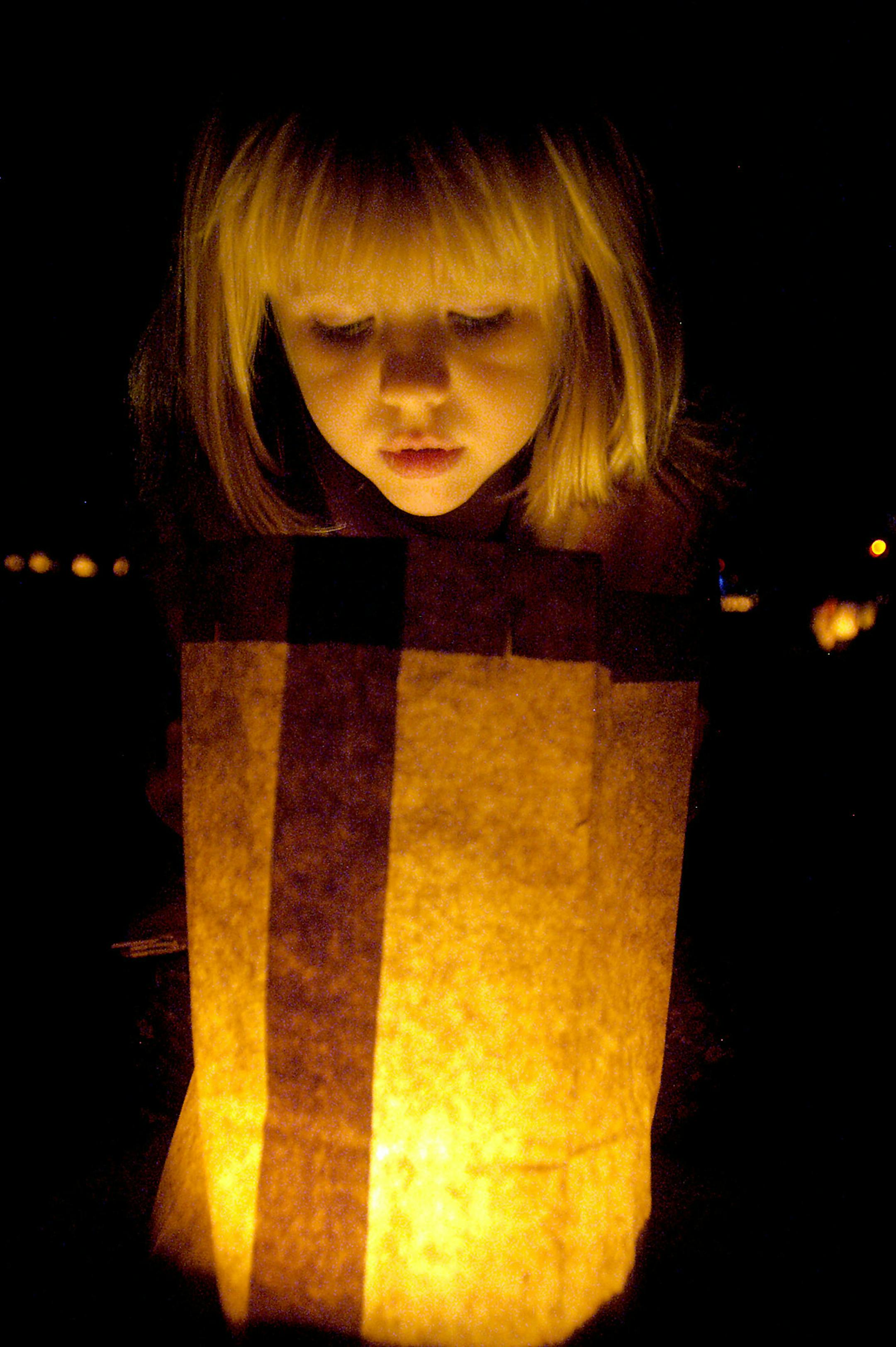 Della Olberding, 5, looks into a luminaria, or paper lantern, Sunday Dec. 7, 2008 at New Mexico State University in Las Cruces, N.M. She and her family strolled along the campus that was lined with 5,000 luminarias, making it one of the largest luminaria displays in southern New Mexico, according to an NMSU news release. (AP Photo/Las Cruces Sun-News, Norm Dettlaff) ORG XMIT: NMLCR101