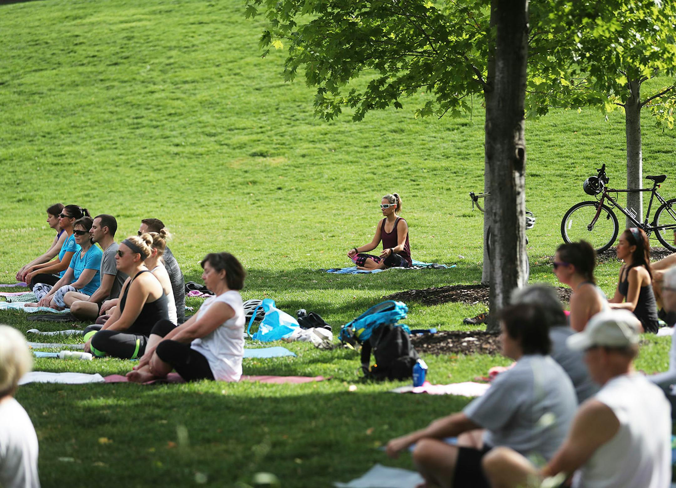 The Downtown Minneapolis Neighborhood Association has worked in conjunction with the Gold Medal Park Foundation in order to offer up free yoga classes for the growing population of Minneapolis. Here, participants in the yoga class begin their morning Saturday, June 17, 2017, in Gold Medal Park in Minneapolis, MN.