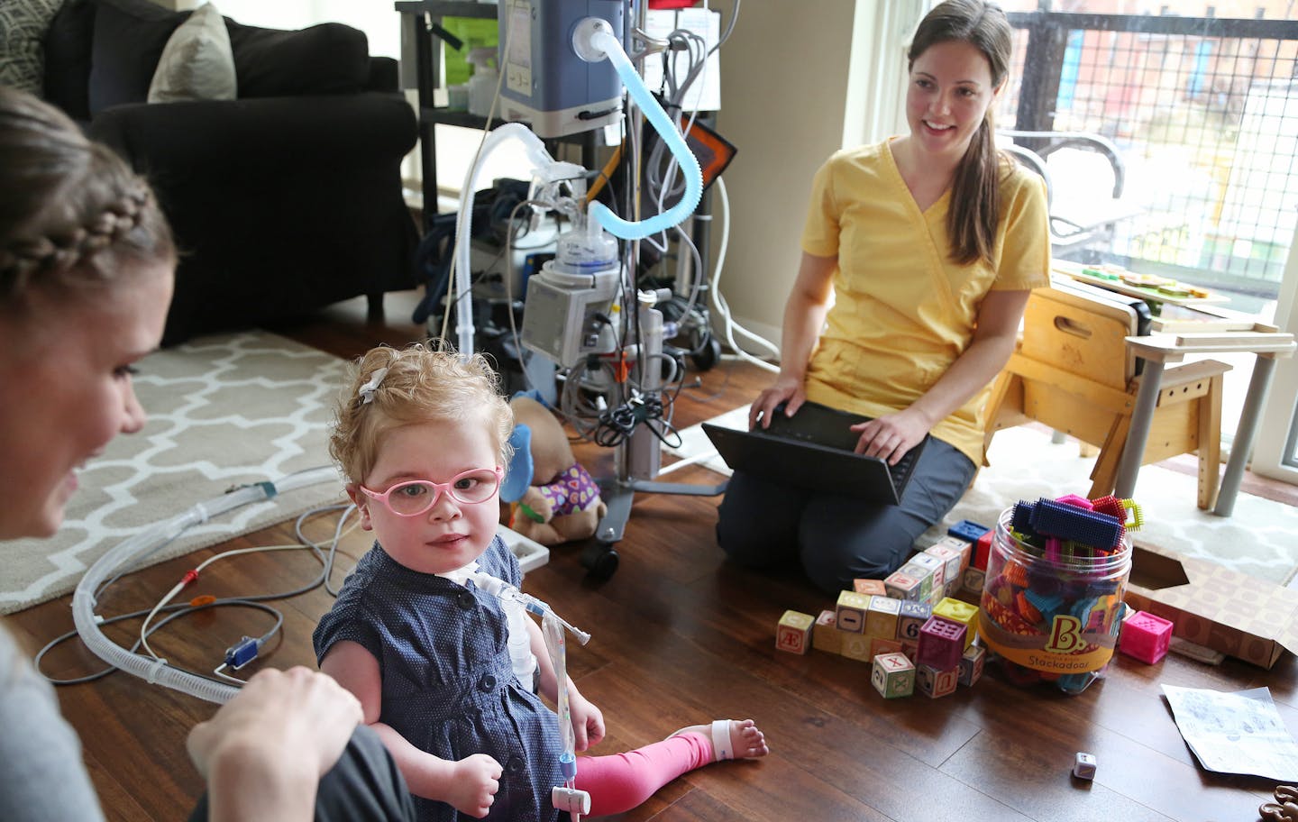 RN Lindsay Powell right helped Sara Raunaas give treatment to her daughter Elsa Raunaas at their condo Wednesday May 20, 2015 in Minneapolis, MN. Lindsay is a nurse at Pediatric Home services, a company that has been named one of the top 3 workplaces. Jerry Holt/ Jerry.Holt@Startribune.com