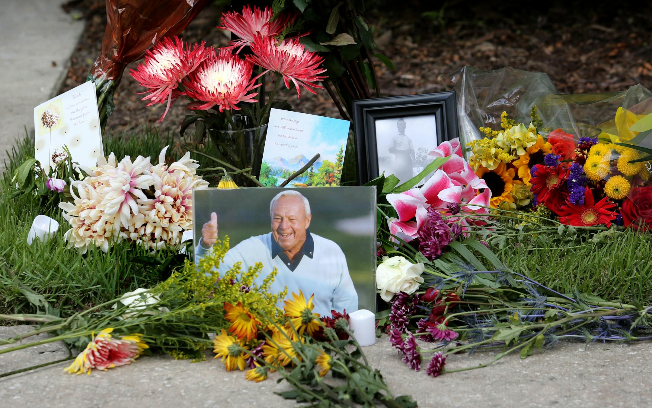 Flowers and mementos adorned a makeshift memorial honoring the late golf great Arnold Palmer at Palmer's parking spot at the Golf Channel studios in Orlando, Fla., on Monday. Palmer died Sunday in Pittsburgh.