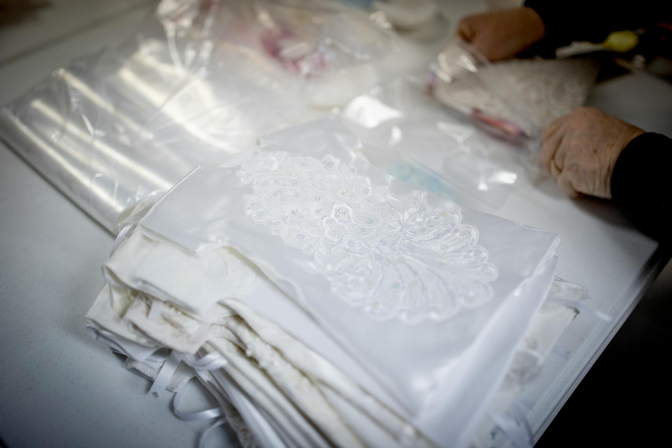 Patty Hauer's church group organize "Angel Dresses" and other items to be packaged for delivery in the All Saints Lutheran Church basement in  Darwin, Minn.