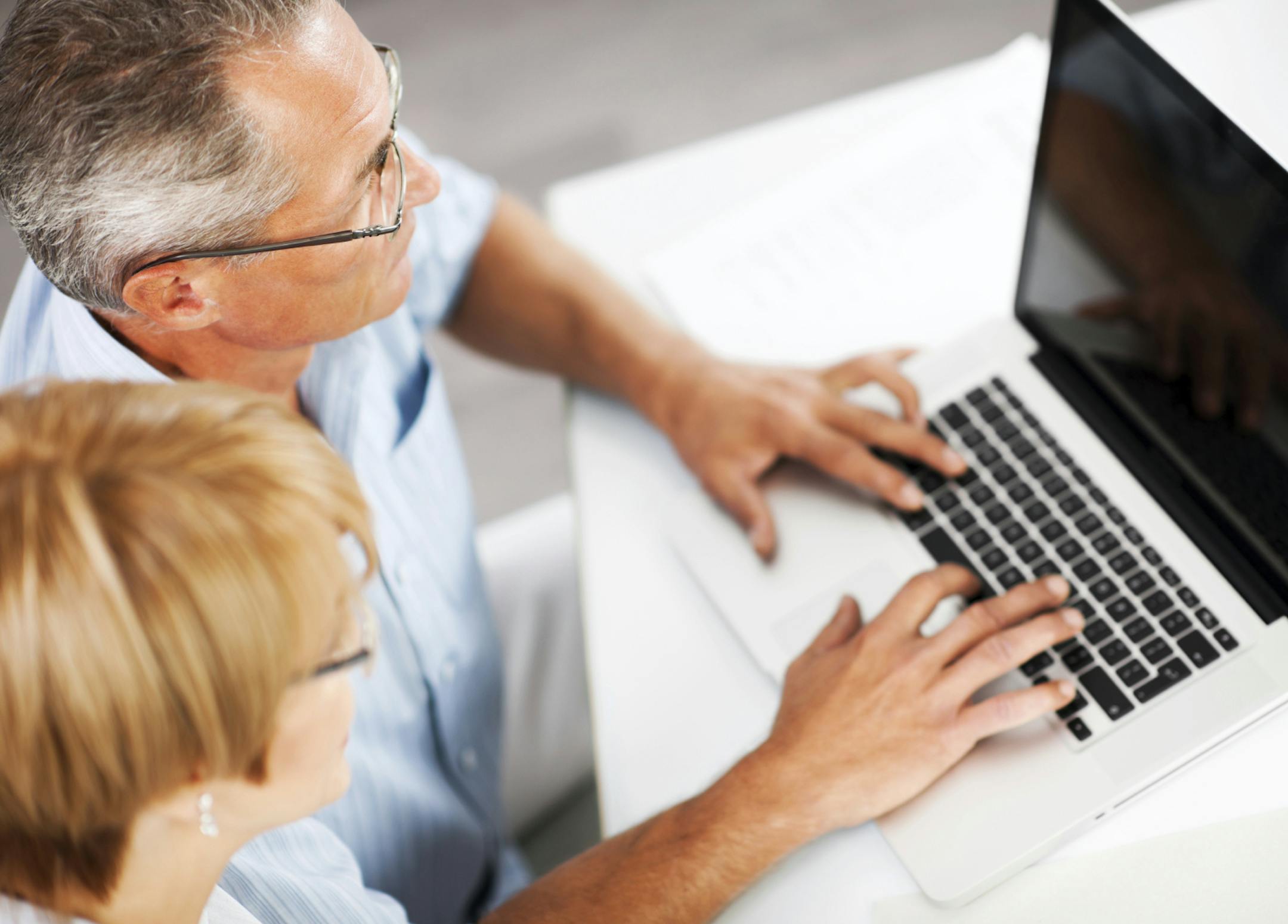 Two people working on a laptop.