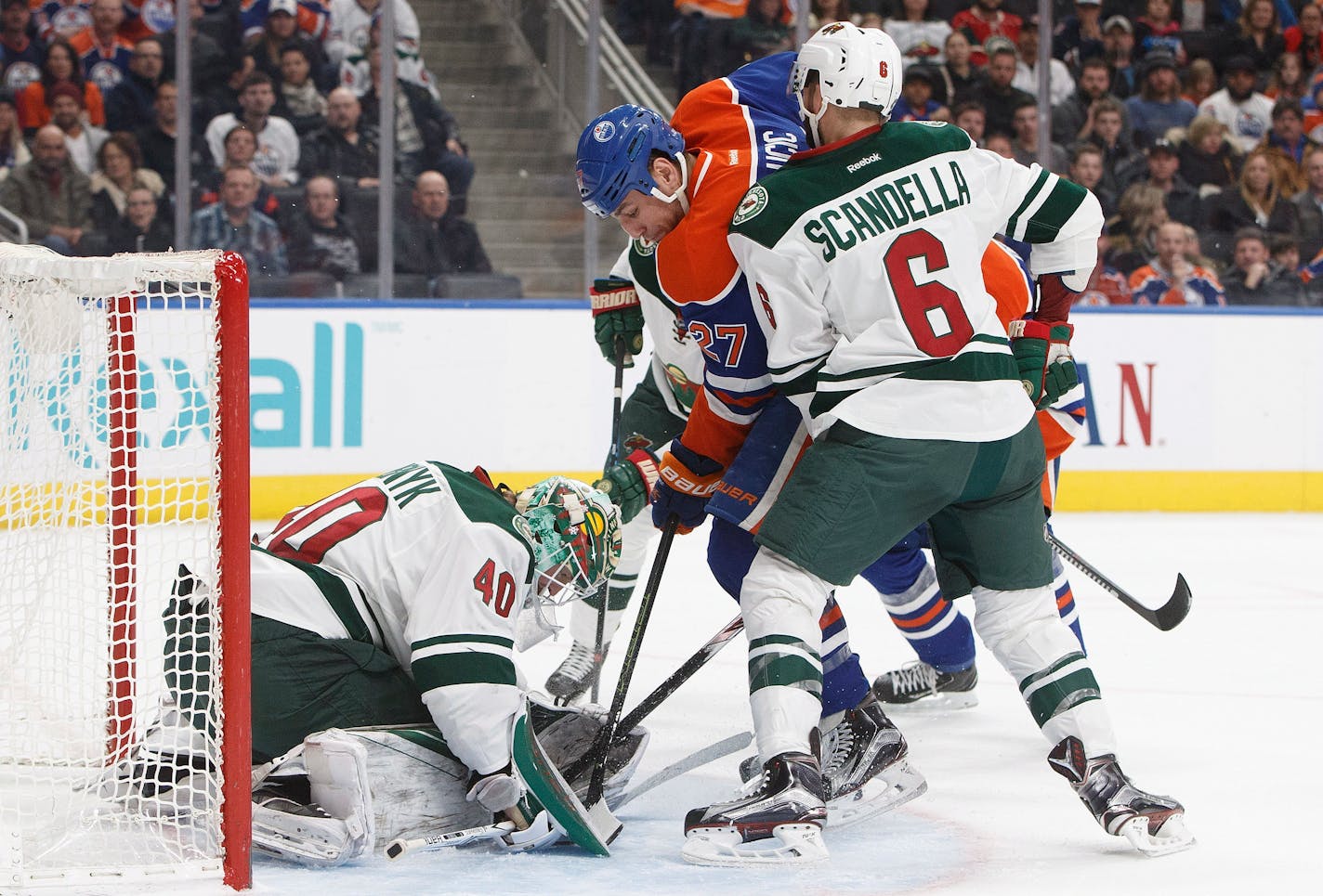 Minnesota Wild goalie Devan Dubnyk (40) makes a save as Edmonton Oilers' Milan Lucic (27) and Marco Scandella (6) battle in front during the second period of an NHL hockey game in Edmonton, Alberta, Sunday, Dec. 4, 2016. (Jason Franson/The Canadian Press via AP)