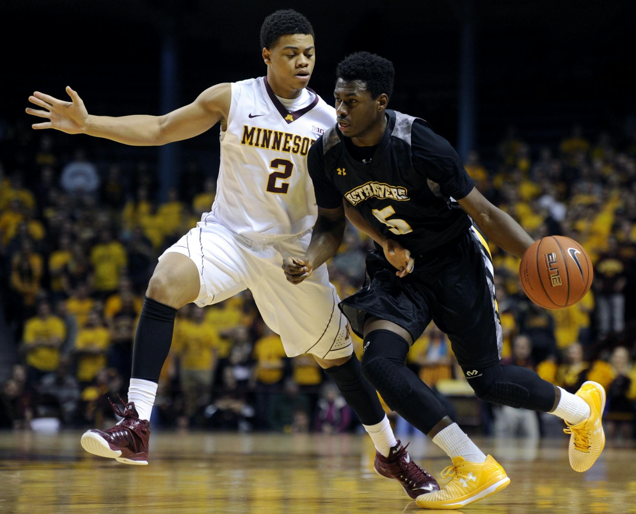 Minnesota guard Nate Mason (2) defends against Maryland-Baltimore County guard Jourdan Grant (5) during the first half of an NCAA college basketball game Saturday, Nov. 22, 2014, in Minneapolis.