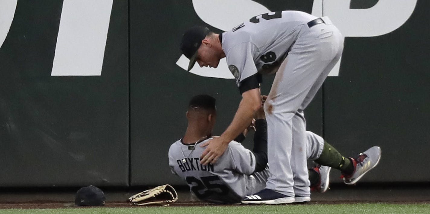 Twins right fielder Max Kepler, right, checked on center fielder Byron Buxton after Buxton crashed into the wall while trying to catch a two-run home run hit by the Mariners' Nelson Cruz during the sixth inning Saturday.