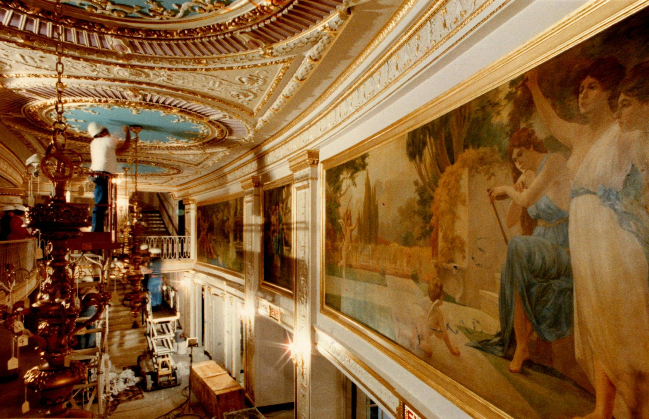October 11, 1991 The Crystal Chandeliers at the STATE theater are going up now, nearing completion of the 8 million dollar restoration project. The Chandeliers have sat in storage for nearly 10 yrs. waiting for their proper mounting place, they are worth nearly 75 thousand dollars each and display gold gilded cherubs, crystal grape clusters and multiple sized crystal danglies. the Fresco paintings and raised areas on the ceilings all add to the glitter and the old glamor of the STATE. Workers ar