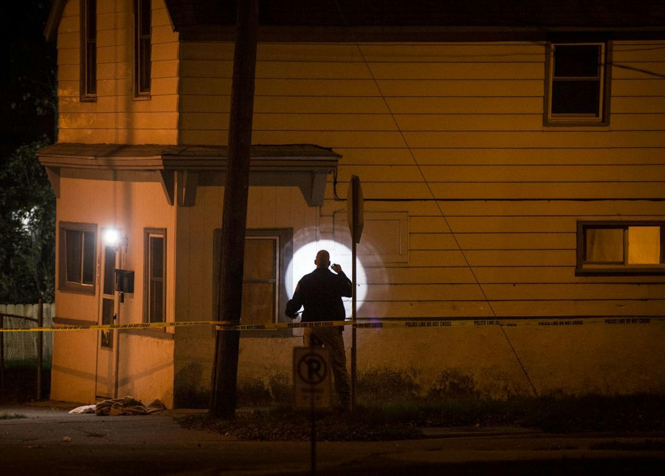 An Investigator used his flashlight to look for evidence near the scene of a fatal shooting at Beaumont Street East and Bedford Street in St. Paul Sunday night.