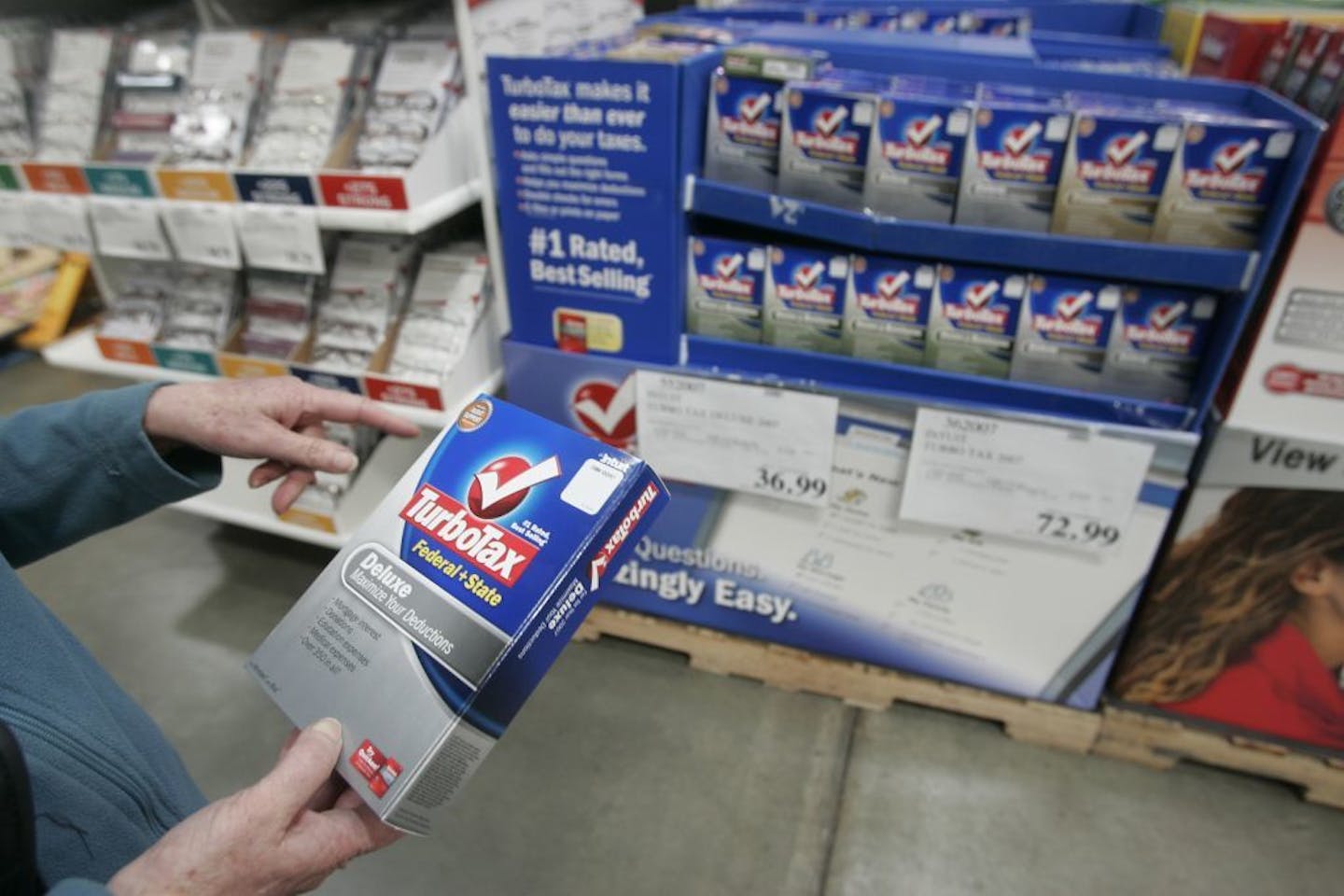 FILE - In this Wednesday, March 5, 2008, file photo. a Costco shopper purchases TurboTax at Costco in Mountain View, Calif. According to a three-month AP investigation released in January 2013, five years after the start of the Great Recession, instead of relying on someone else in the workplace or their personal lives, people are using technology to do tasks independently. (AP Photo/Paul Sakuma, File) ORG XMIT: MIN2013030816342343 ORG XMIT: MIN1303081853583902