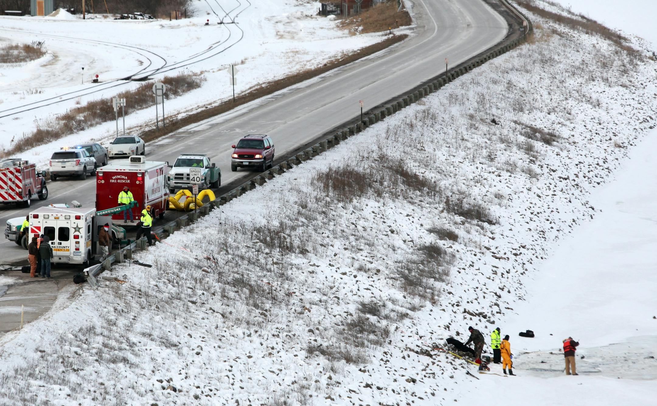 Emergency crews work to recover a vehicle from the Mississippi River on Riverview Drive near Huff Street in Winona, Minn., on Sunday, Jan. 5, 2014.