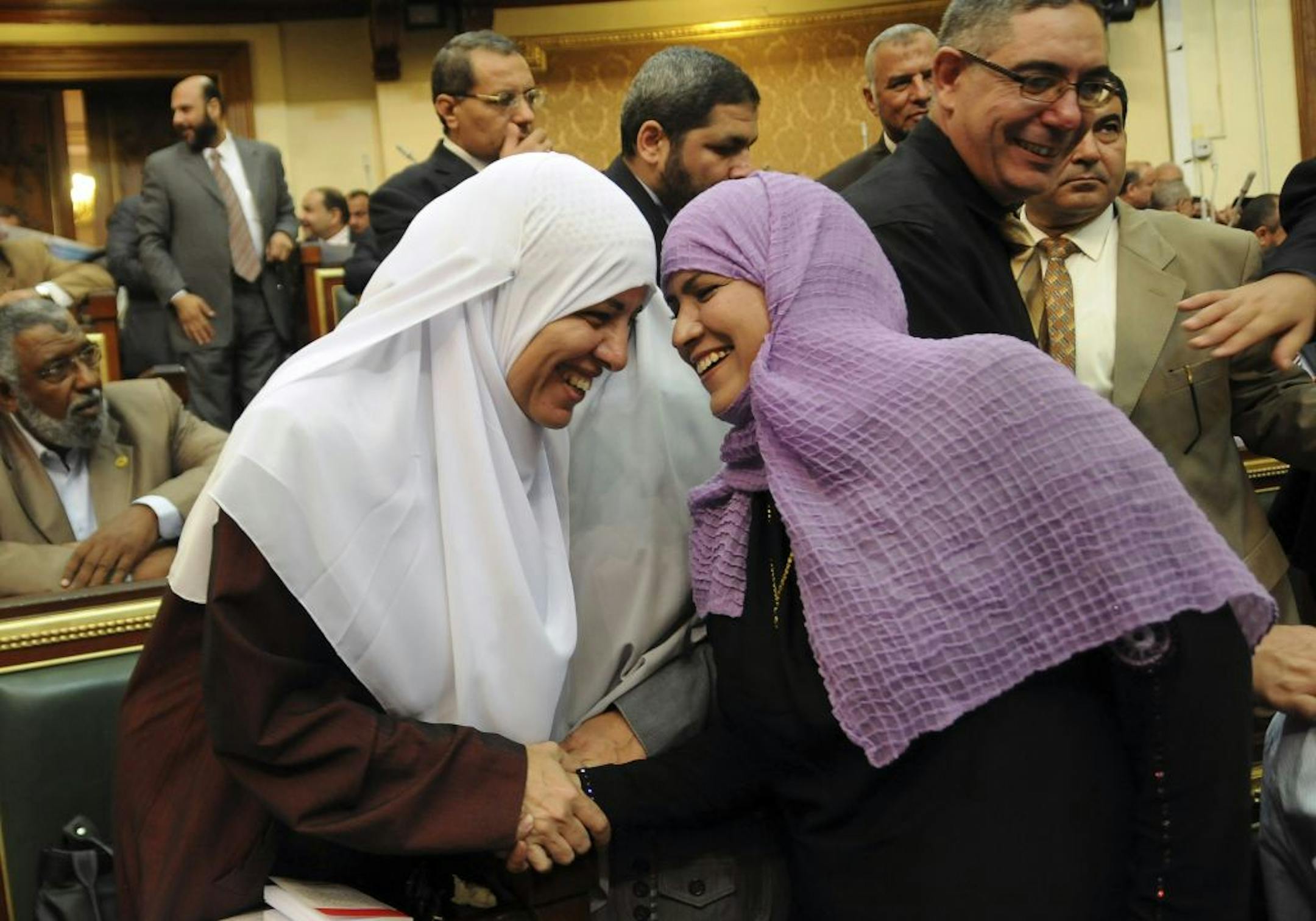 Two female Egyptian lawmakers greet each other at a brief session of Parliament, the first since the country's high court ruled the chamber unconstitutional, in Cairo, Egypt, Tuesday, July 10, 2012.