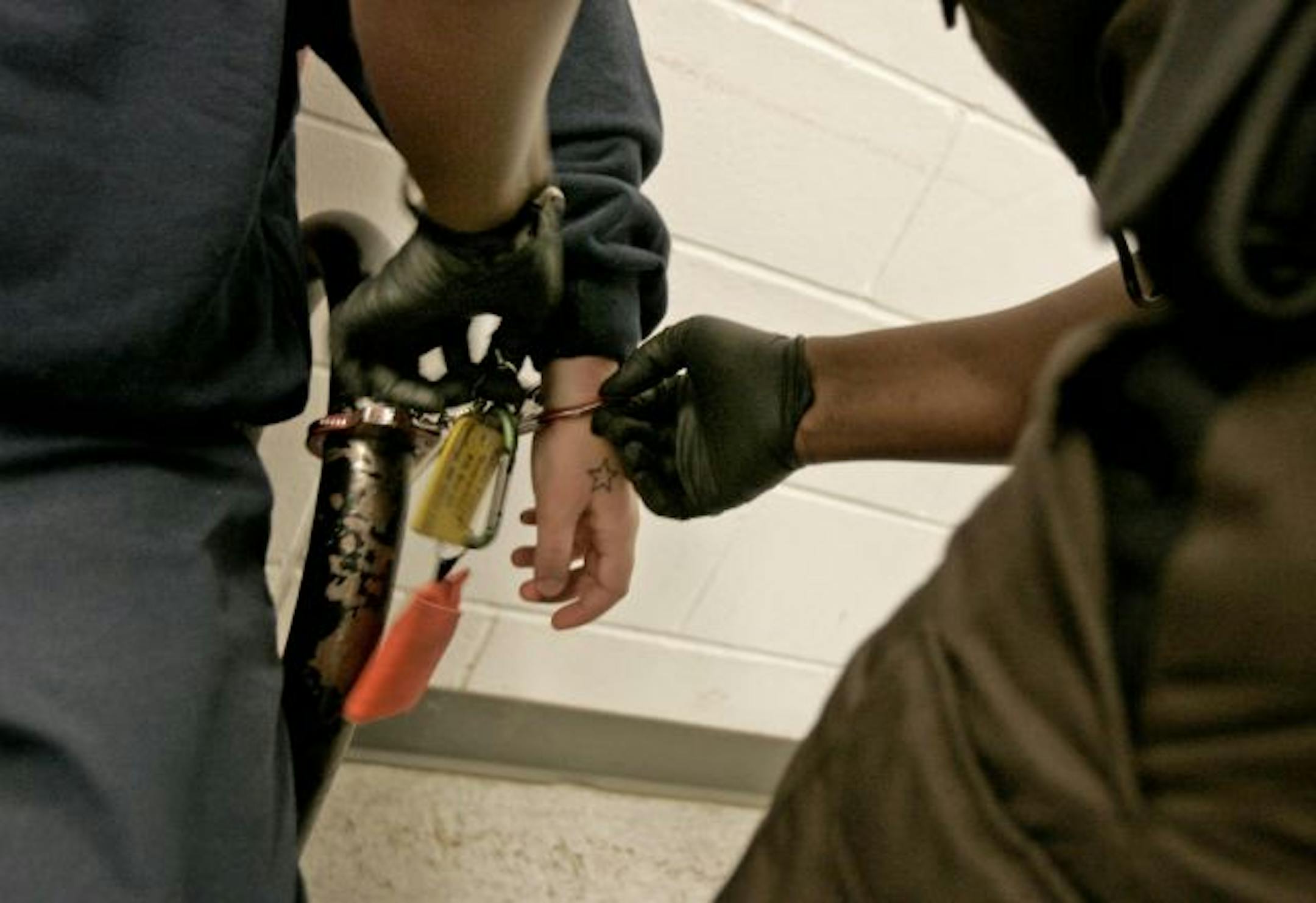 An inmate from Dakota County, housed at Ramsey County's workhouse, has restraints removed after being transported.