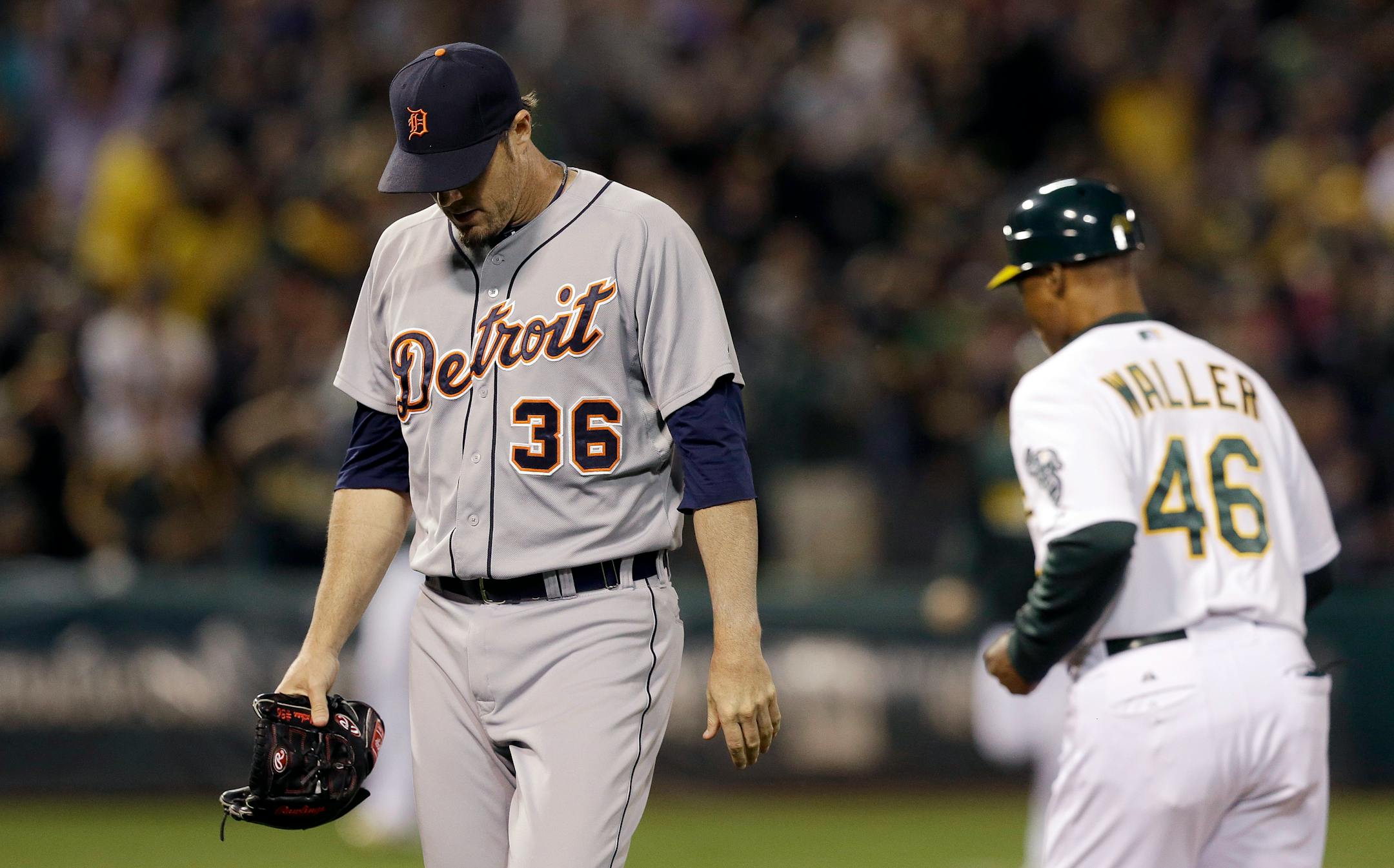 Detroit Tigers pitcher Joe Nathan (36) walks off the field past Oakland Athletics first base coach Tye Waller (46) after allowing a three-run home run to Josh Donaldson during the ninth inning of a baseball game in Oakland, Calif., Wednesday, May 28, 2014. The Athletics won 3-1. (AP Photo/Jeff Chiu)