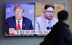 FILE - In this May 11, 2018, file photo, a man watches a TV screen showing file footage of U.S. President Donald Trump, left, and North Korean leader 