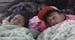 Fabiola Izaguirre and her brother Josue, both of Honduras, begin to wake up after sleeping near the Chaparral border crossing in Tijuana, Mexico, Frid