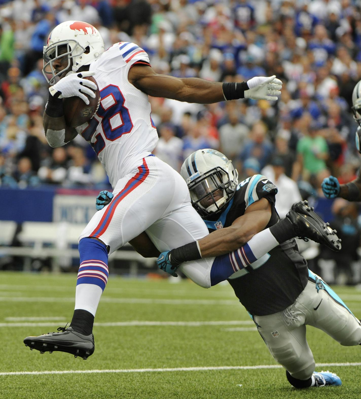 Buffalo Bills' C J Spiller (28) jumps over Carolina Panthers' Mike Mitchell (21) as Panthers' Thomas Davis (58) closes during an NFL football game Sunday, Sept. 15, 2013, in Orchard Park, N.Y. (AP Photo/Gary Wiepert) ORG XMIT: MIN2013100919314126